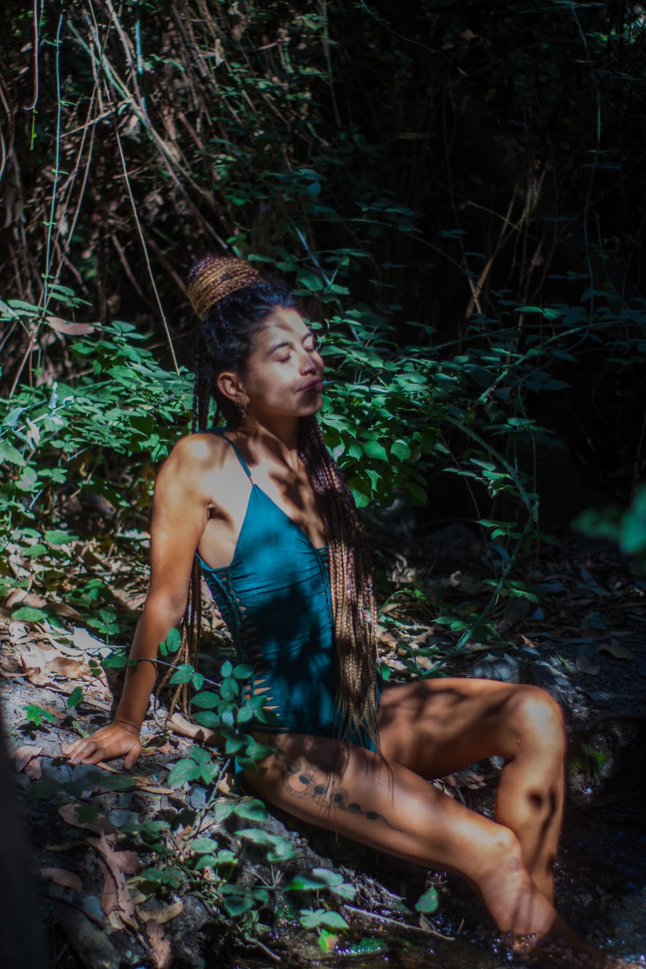 Estefi sentada en un arroyo del bosque, conectando con la naturaleza